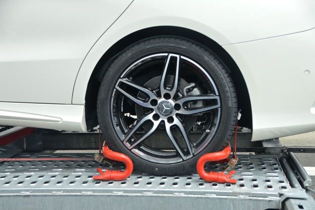 A car loaded with locked tires on a tow truck